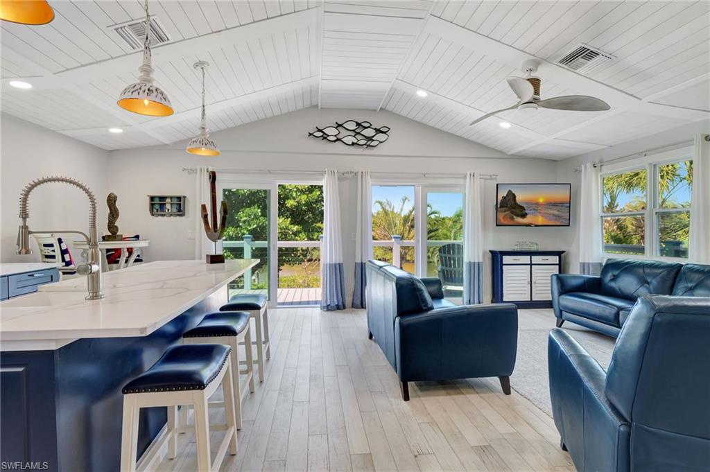 193 Cocohatchee Street Naples, FL 34110 - Photo 2 of 50 Upstairs living room featuring light wood-style flooring, lofted ceiling, and a ceiling fan