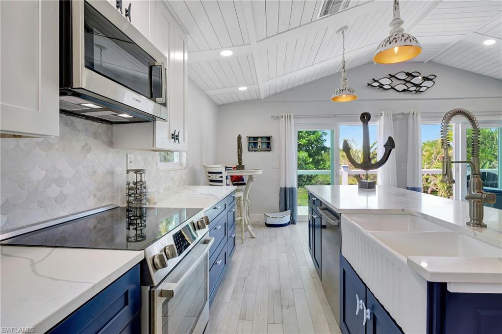 193 Cocohatchee Street Naples, FL 34110 - Photo 6 of 50 Upstairs Kitchen with porcelain farm sink and upgraded pendant lighting and decorative backsplash