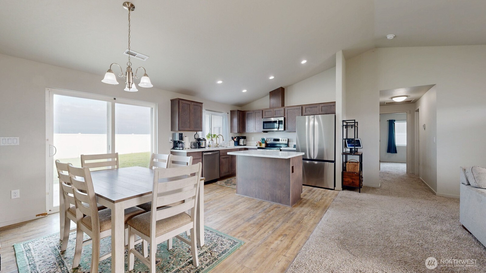 907 East Cascade Street Othello, WA 99344 - Photo 5 of 27 a kitchen with a dining table chairs refrigerator and cabinets