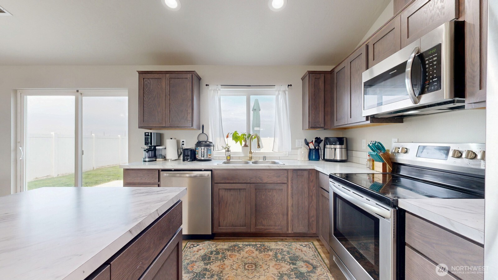 907 East Cascade Street Othello, WA 99344 - Photo 10 of 27 a kitchen with stainless steel appliances granite countertop a sink stove and microwave