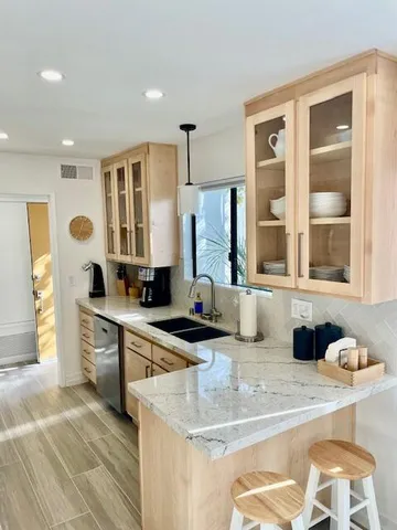 a kitchen with stainless steel appliances granite countertop a sink and a refrigerator