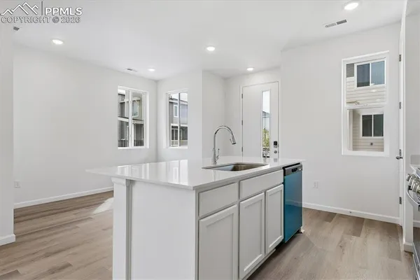 a kitchen with a sink cabinets and wooden floor