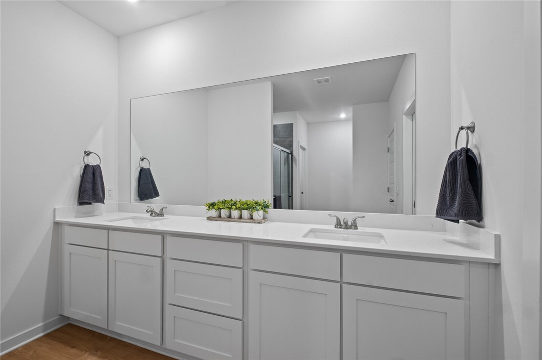 2105 Oliver Street Pea Ridge, AR 72751 - Photo 15 of 26 Dual vanity with white cabinetry, integrated sinks, white countertops, and a large wall-mounted mirror