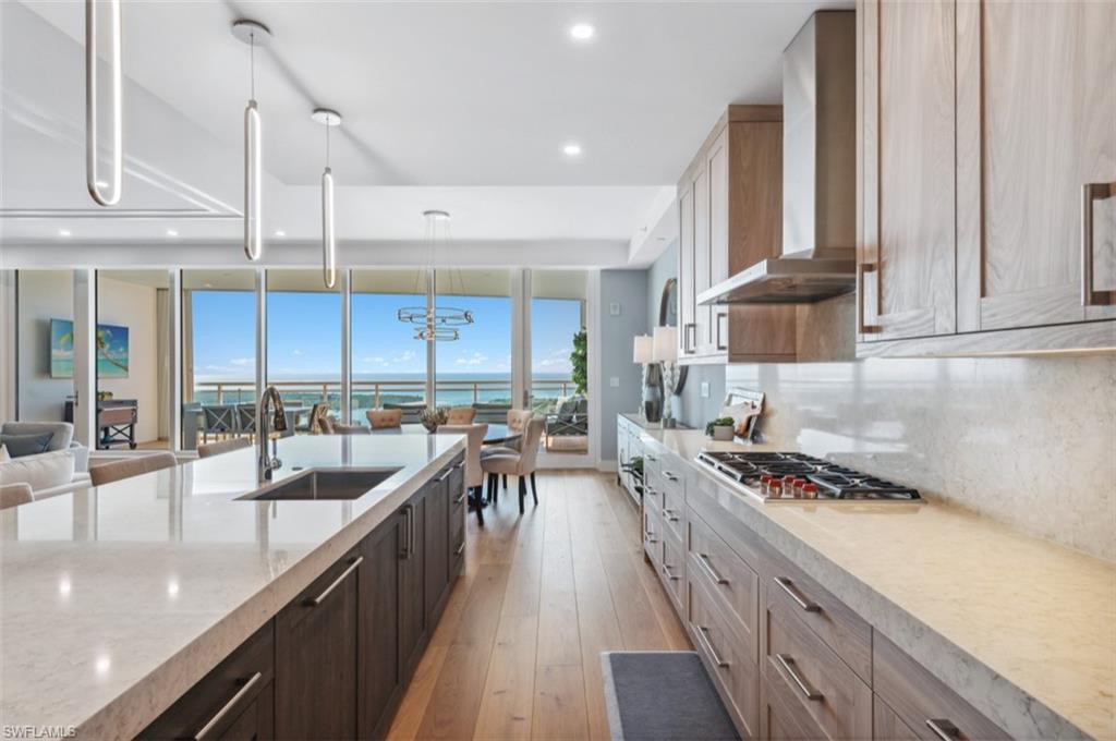 13925 Old Coast Road, Unit PH02 Naples, FL 34110 - Photo 18 of 33 a kitchen with stainless steel appliances a sink a stove and cabinets