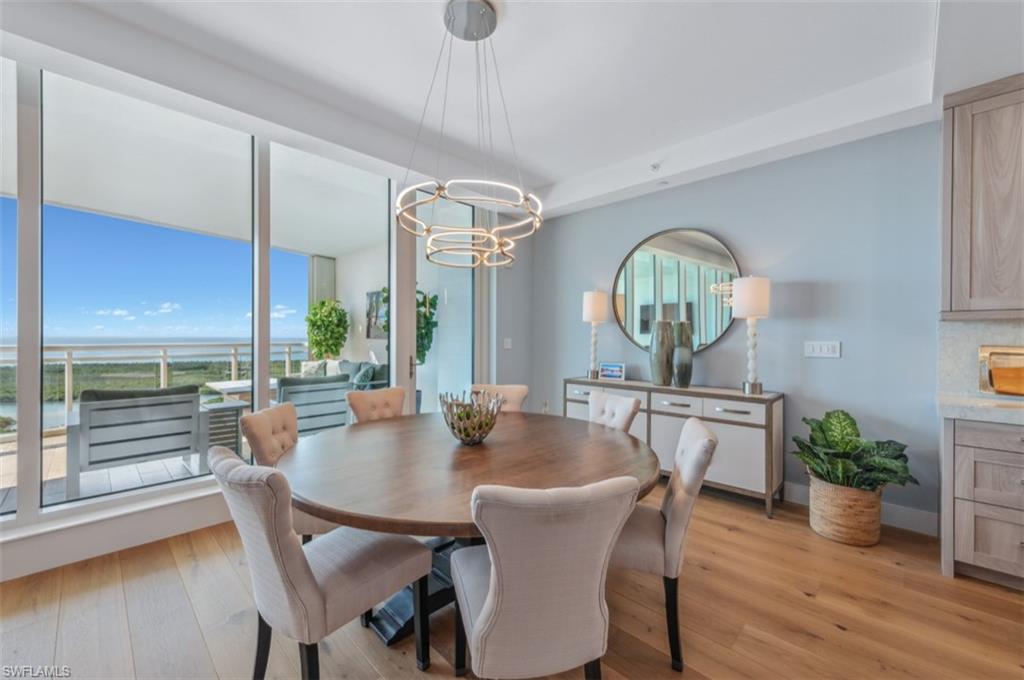13925 Old Coast Road, Unit PH02 Naples, FL 34110 - Photo 21 of 33 a view of a dining room with furniture window and wooden floor