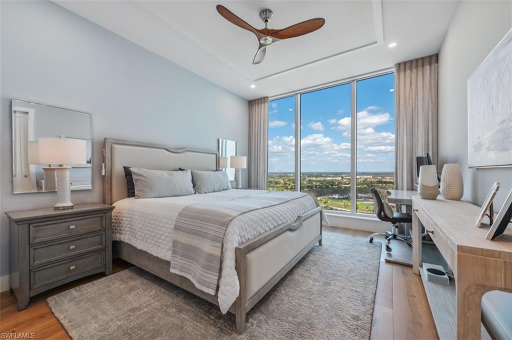 13925 Old Coast Road, Unit PH02 Naples, FL 34110 - Photo 29 of 33 a bedroom with a large bed and a large window