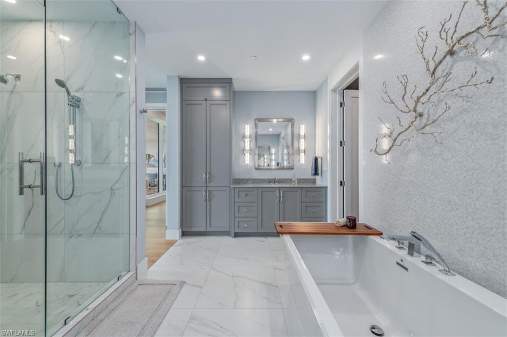 13925 Old Coast Road, Unit PH02 Naples, FL 34110 - Photo 5 of 33 a bathroom with a tub shower and sink