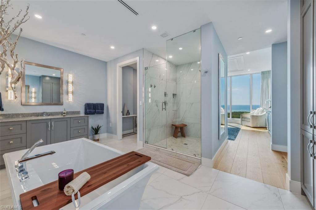 13925 Old Coast Road, Unit PH02 Naples, FL 34110 - Photo 6 of 33 a bathroom with a tub a sink shower and mirror