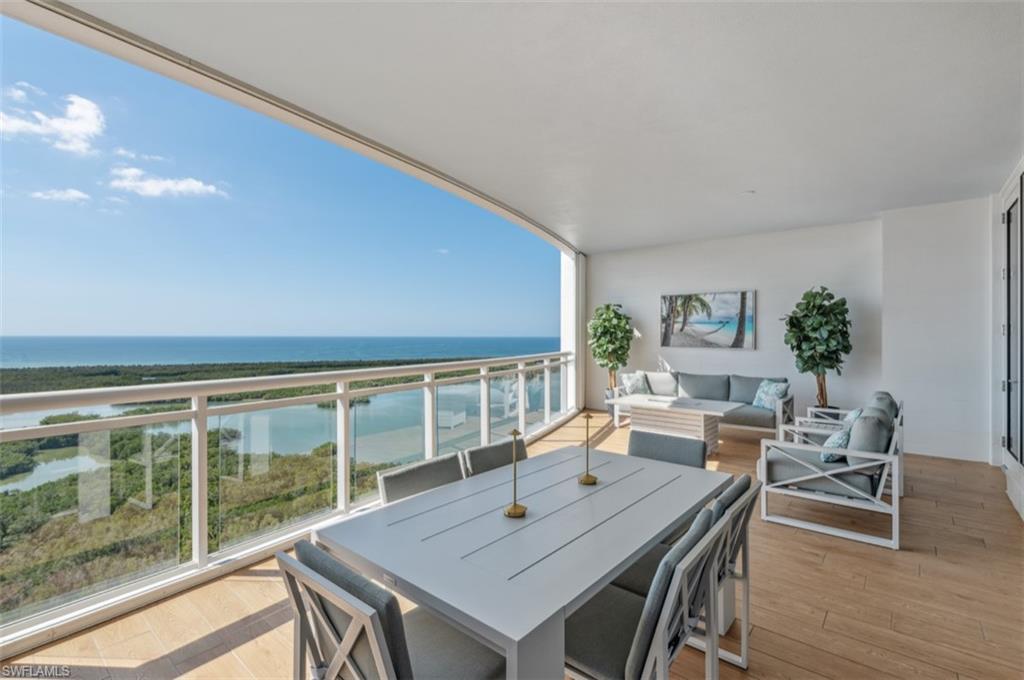 13925 Old Coast Road, Unit PH02 Naples, FL 34110 - Photo 8 of 33 a view of a dining room with furniture window and wooden floor