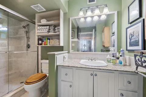 a bathroom with a granite countertop sink toilet and shower