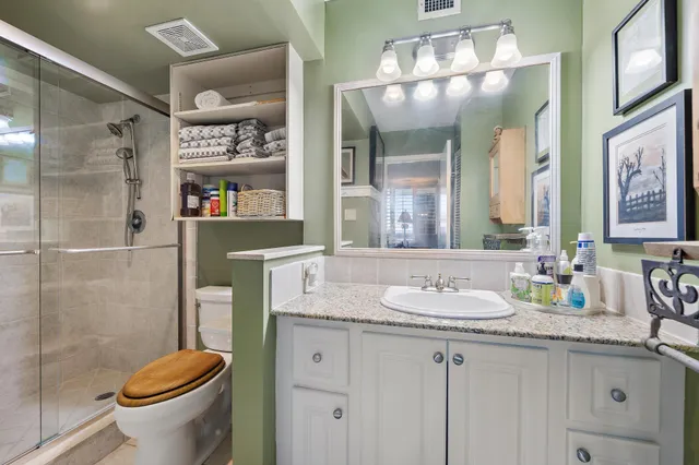 a bathroom with a granite countertop sink toilet and shower