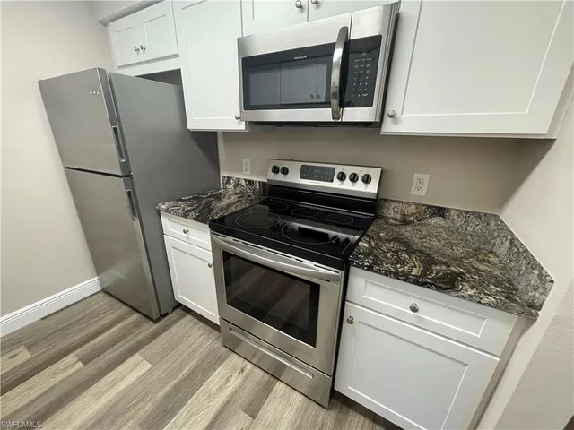 a kitchen with stainless steel appliances granite countertop a refrigerator stove and microwave