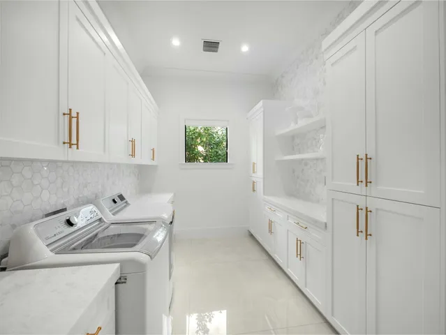 a view of a dining room with furniture a chandelier and large windows