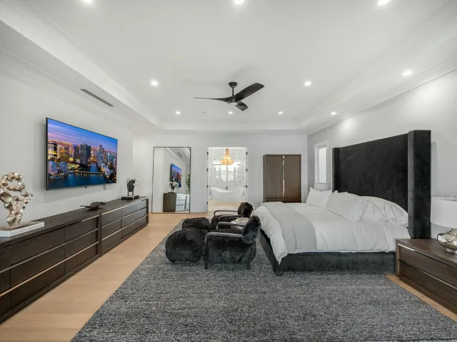 a view of an empty room with wooden floor and windows