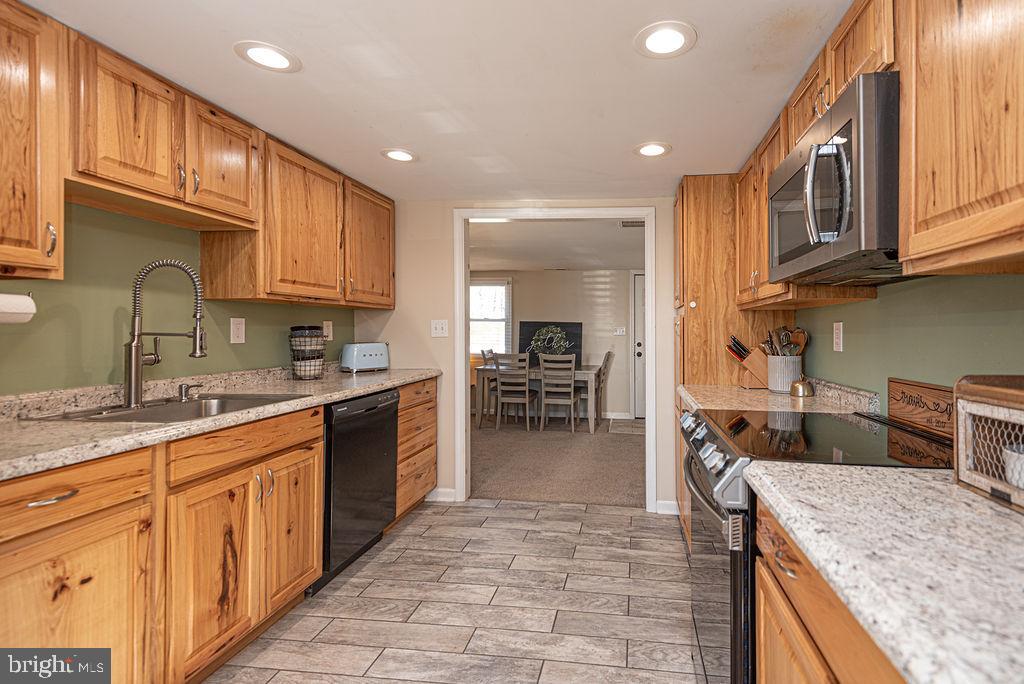 9530 Peerless Road Bishopville, MD 21813 - Photo 13 of 51 a kitchen with stainless steel appliances granite countertop a sink stove and cabinets