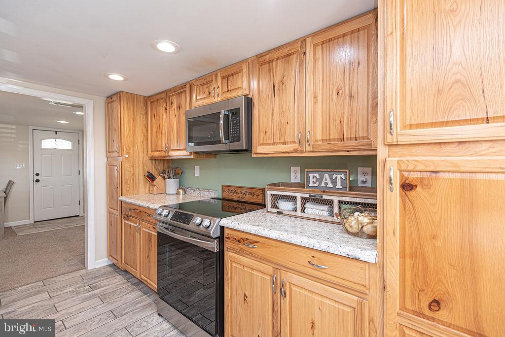 9530 Peerless Road Bishopville, MD 21813 - Photo 14 of 51 a kitchen with stainless steel appliances granite countertop a stove a sink and a microwave