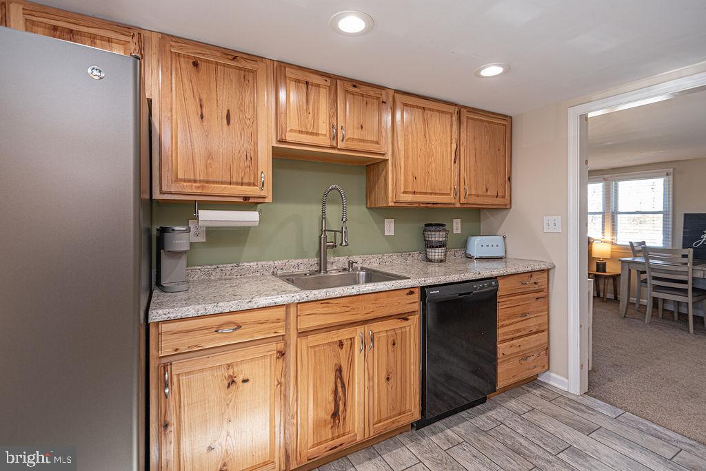 9530 Peerless Road Bishopville, MD 21813 - Photo 15 of 51 a kitchen with granite countertop wooden cabinets a sink and dishwasher