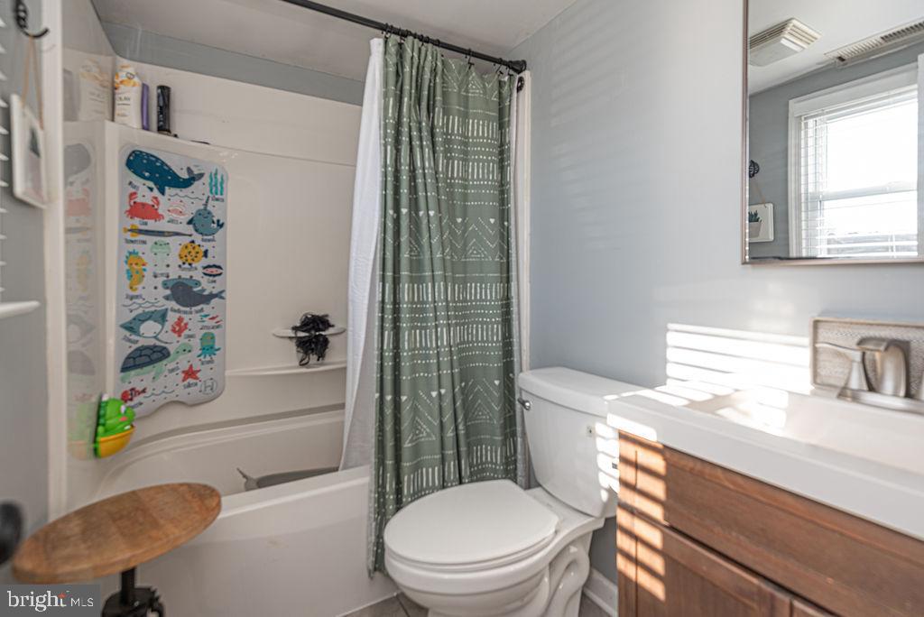 9530 Peerless Road Bishopville, MD 21813 - Photo 23 of 51 a bathroom with a toilet a sink and a shower curtain