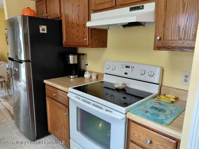 a view of a kitchen with sink and refrigerator