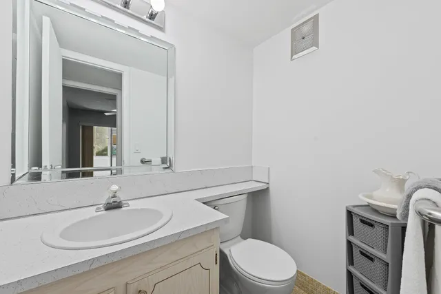 a bathroom with a sink a toilet and mirror