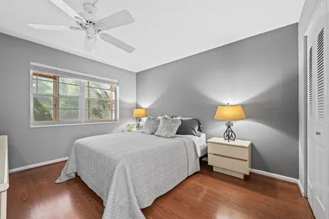 a bedroom with a bed lamp and a large window