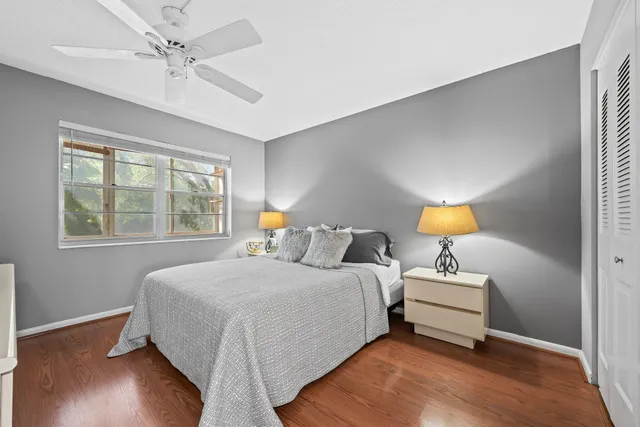 a bedroom with a bed lamp and a large window