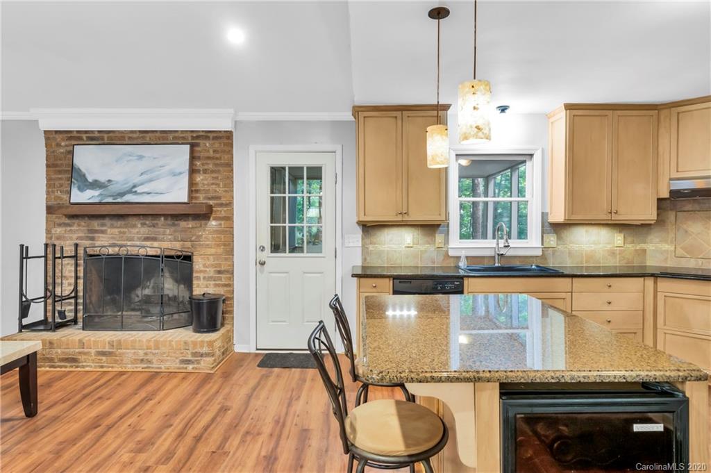 7109 New Town Road Waxhaw, NC 28173 - Photo 16 of 31 a kitchen with granite countertop a stove a sink and a wooden cabinets