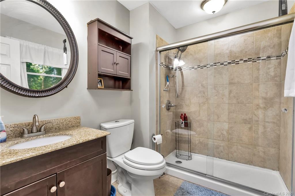 7109 New Town Road Waxhaw, NC 28173 - Photo 19 of 31 a bathroom with a granite countertop toilet sink and mirror