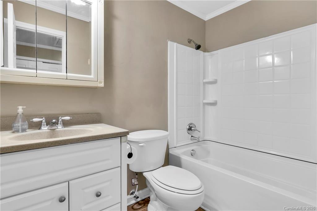 7109 New Town Road Waxhaw, NC 28173 - Photo 22 of 31 a bathroom with a granite countertop sink toilet a mirror and shower