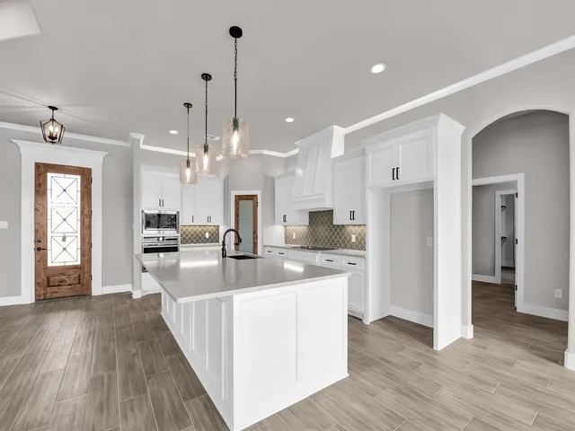 a large kitchen with stainless steel appliances kitchen island a large counter top and a wooden floors