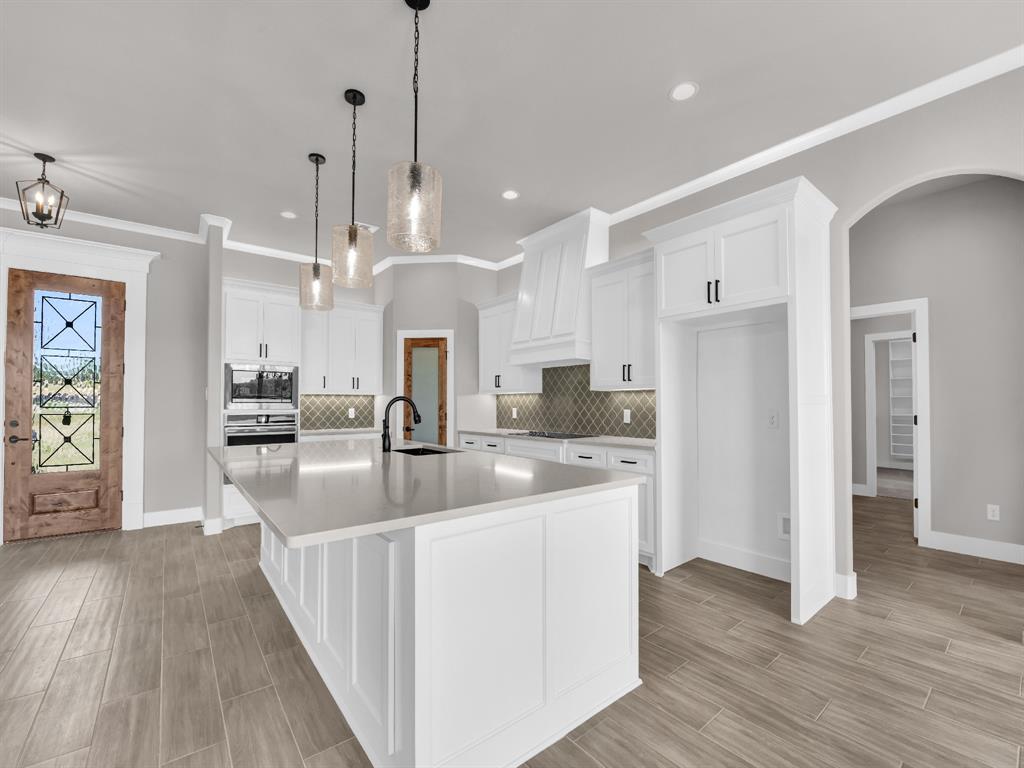 2000 Forest Bridge Drive Azle, TX 76020 - Photo 17 of 34 a large kitchen with stainless steel appliances kitchen island granite countertop a refrigerator a oven and a wooden floors