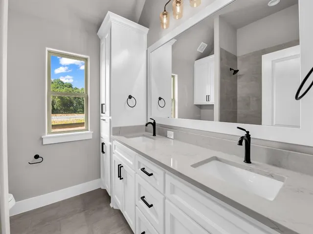 a bathroom with a double vanity sink and a mirror