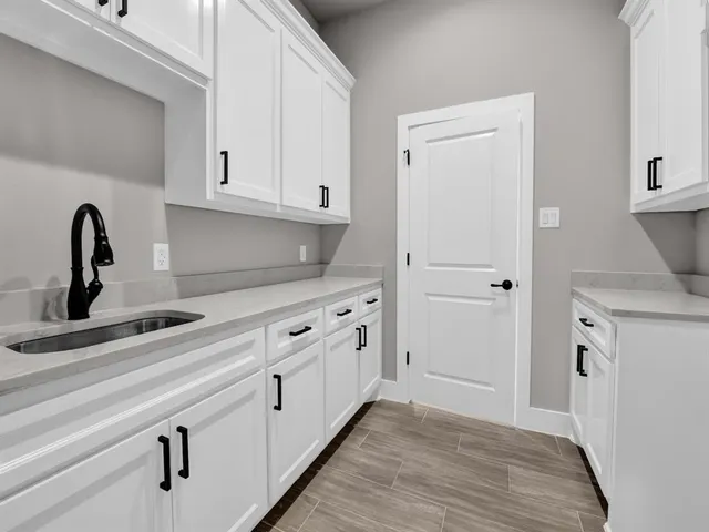a kitchen with white cabinets and sink
