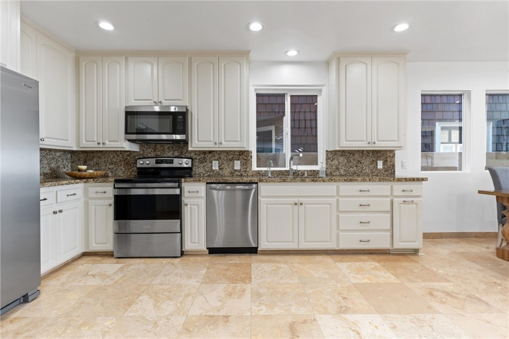 2804 West Oceanfront Newport Beach, CA 92663 - Photo 11 of 41 a kitchen with white cabinets stainless steel appliances and window