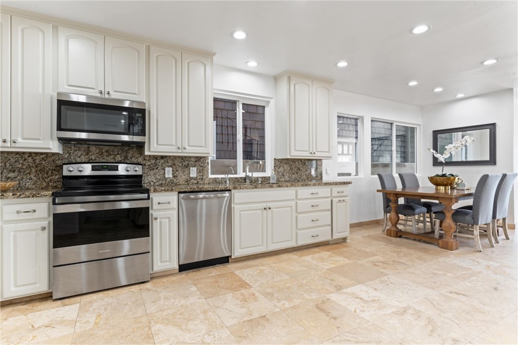 2804 West Oceanfront Newport Beach, CA 92663 - Photo 12 of 41 a kitchen with stainless steel appliances granite countertop a stove a sink a microwave a dining table and chairs