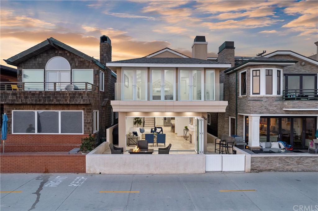 2804 West Oceanfront Newport Beach, CA 92663 - Photo 2 of 41 a view of a big house with large windows and a small yard