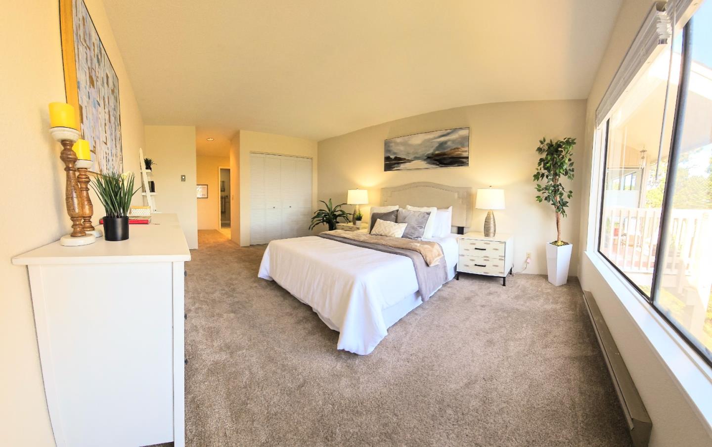 40 Shepherds Knoll Road, Unit 40 Monterey, CA 93940 - Photo 34 of 52 a spacious bedroom with a bed and a large mirror next to a window