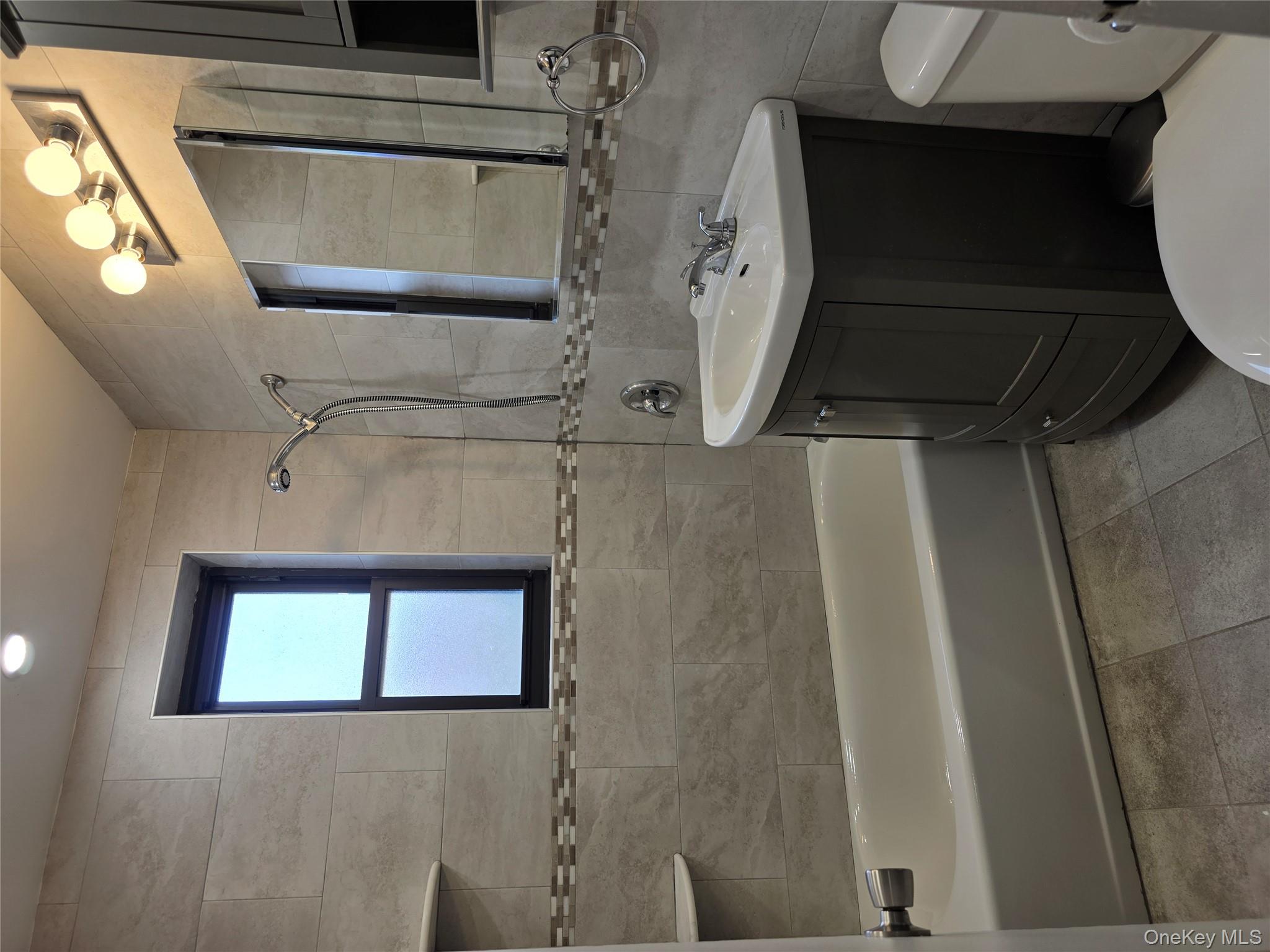 84-01 Main Street, Unit 506 Queens, NY 11435 - Photo 14 of 25 a bathroom with a sink vanity mirror bathtub shower and a toilet