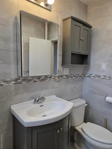 a bathroom with a sink a toilet and mirror