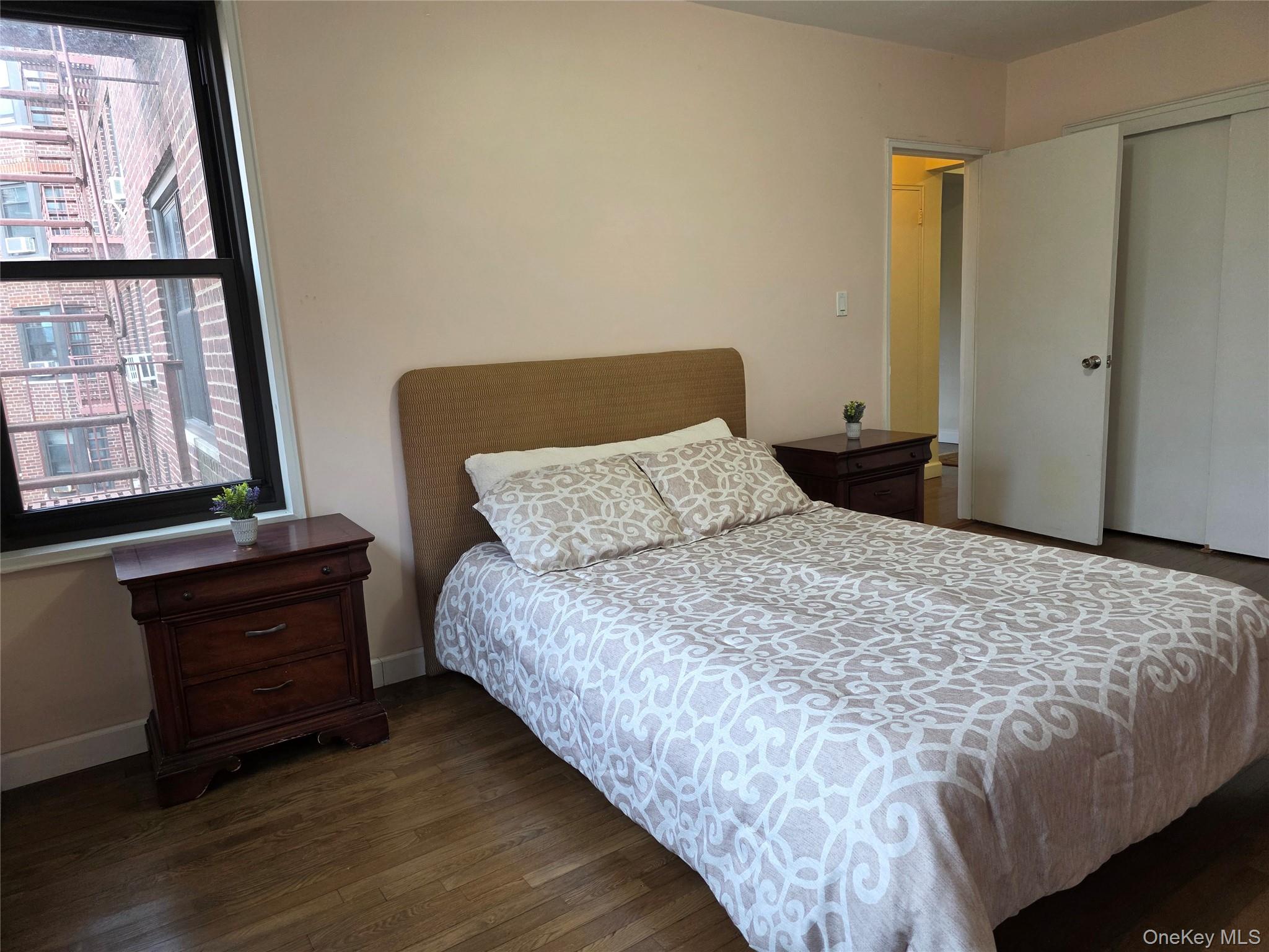 84-01 Main Street, Unit 506 Queens, NY 11435 - Photo 17 of 25 a bedroom with a bed and wooden floor