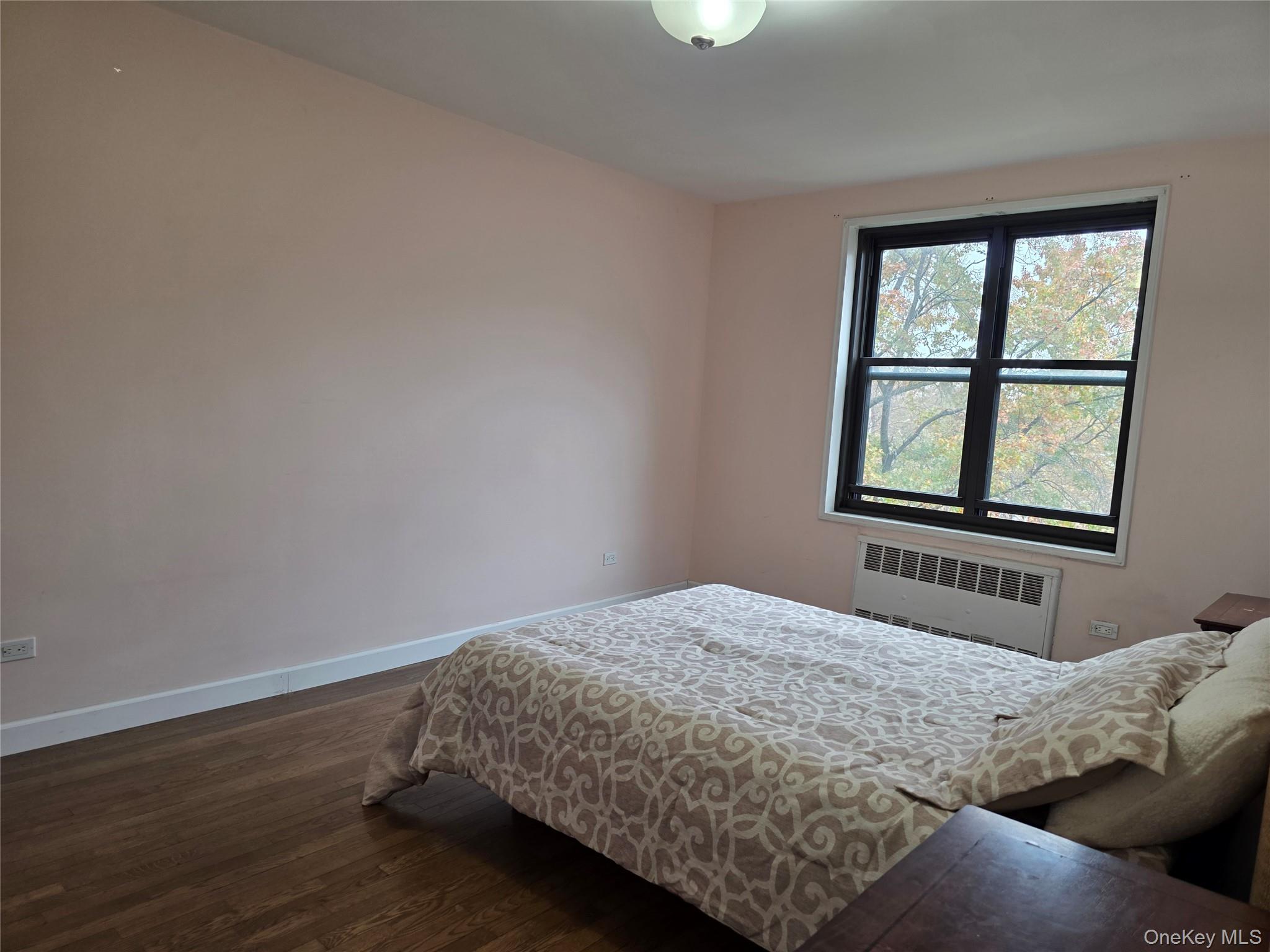 84-01 Main Street, Unit 506 Queens, NY 11435 - Photo 19 of 25 a bedroom with a bed and wooden floor