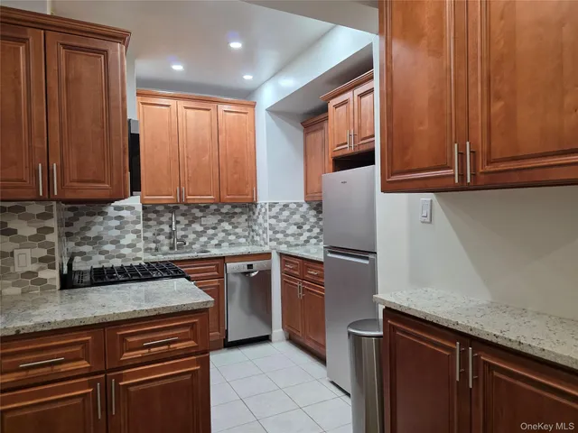 a kitchen with stainless steel appliances granite countertop wooden cabinets a sink and dishwasher