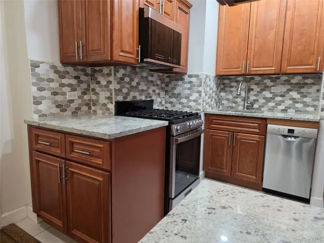 a kitchen with stainless steel appliances granite countertop a sink stove and microwave