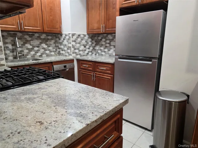 a kitchen with granite countertop a refrigerator and a stove