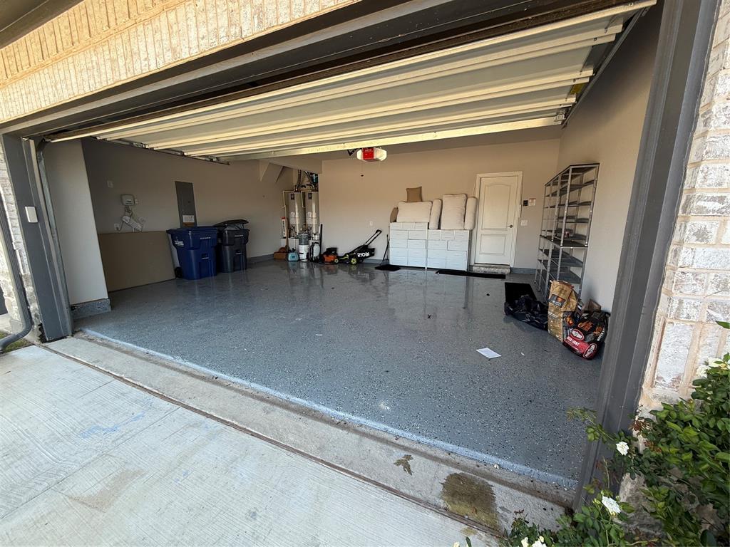 5212 Troupe Road McKinney, TX 75071 - Photo 37 of 38 Spacious garage featuring a durable epoxy-coated floor, painted walls, and a convenient interior access door