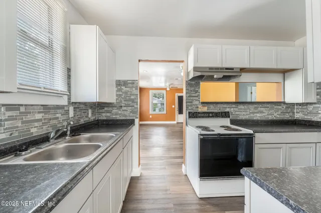 a kitchen with stainless steel appliances granite countertop a sink stove and microwave