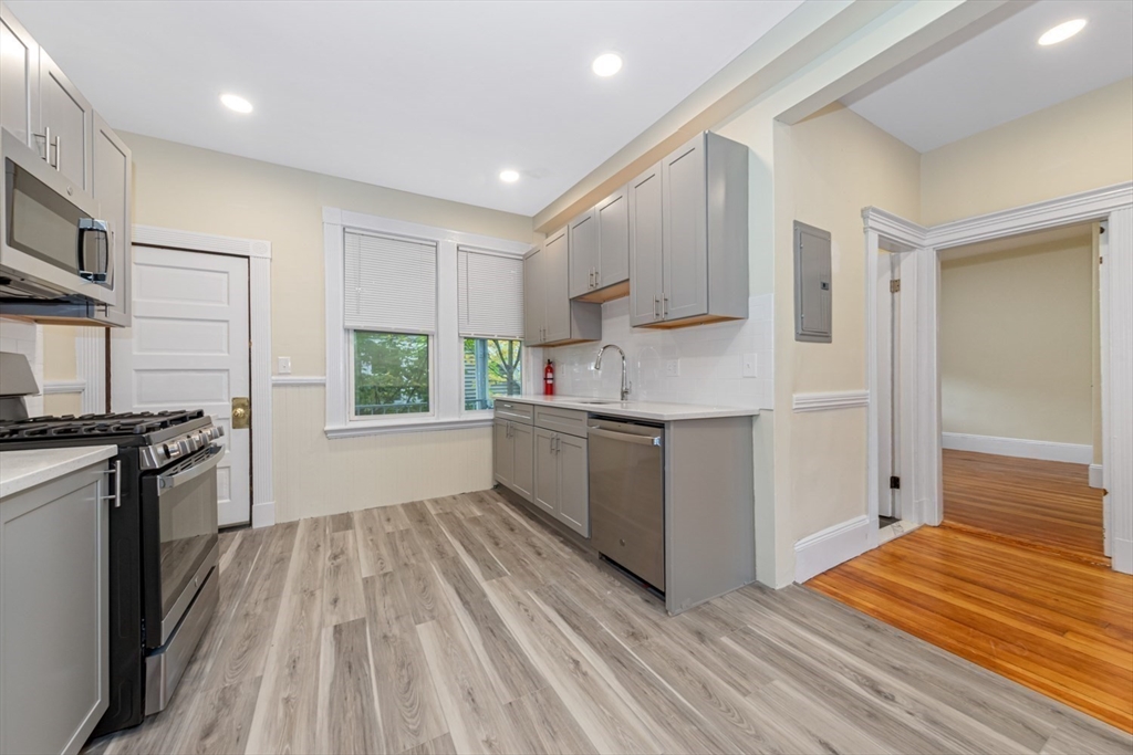44 Brackett Street, Unit 3 Boston, MA 02135 - Photo 15 of 28 a kitchen with stainless steel appliances granite countertop a stove a sink and a refrigerator