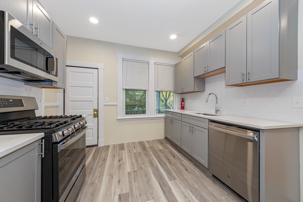 44 Brackett Street, Unit 3 Boston, MA 02135 - Photo 16 of 28 a kitchen with a sink stove top oven and cabinets