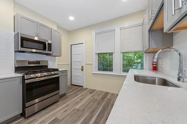 a kitchen with stainless steel appliances a stove a sink and a microwave