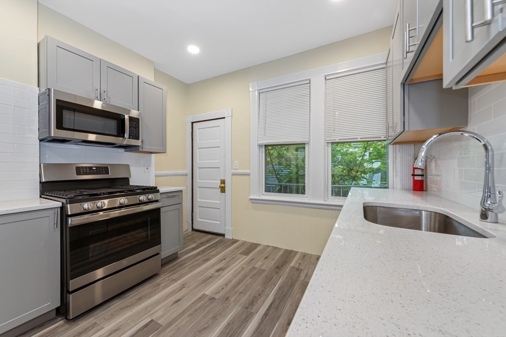 44 Brackett Street, Unit 3 Boston, MA 02135 - Photo 20 of 28 a kitchen with stainless steel appliances a stove a sink and a microwave